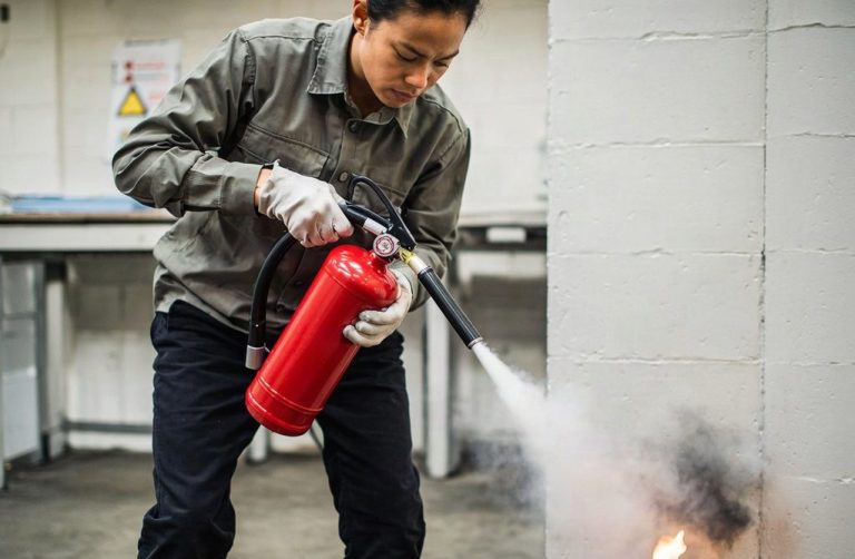Personne utilisant un extincteur pour éteindre un début d'incendie
